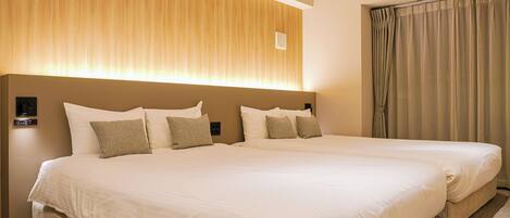 A double bed with a headboard, a bedside table, and a wall-mounted control panel.
