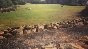 A building with a flat roof and a grassy yard.