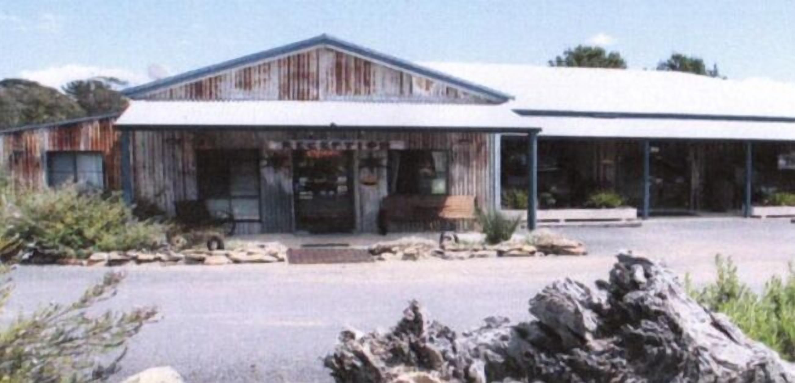 A rustic building with a large entrance and a covered porch area.