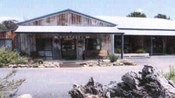 A rustic building with a large entrance and a covered porch area.