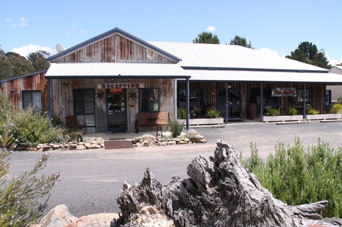 A rustic building with a corrugated metal roof and wooden walls, featuring a shop front with a sign that reads "RESTAURANT."