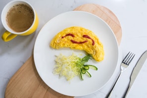 A plate with an omelette, a cup of coffee, and a fork and knife on a wooden board. - Fairfield by Marriott Jingdezhen (Jingdezhen)
