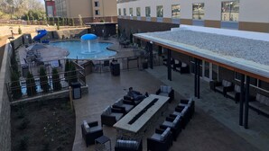 A hotel courtyard with a pool, outdoor seating, and a water slide. - Fairfield Inn & Suites by Marriott Pigeon Forge (Pigeon Forge)