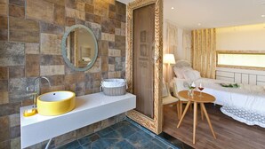 A bathroom with a yellow sink, a mirror, and a shower area with a wooden door. - Healing 11st Pension (Incheon)