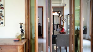 A room with a dining table, a statue, and a hanging light fixture. - The Villa - Luxury Private Pool Villa (Langkawi)
