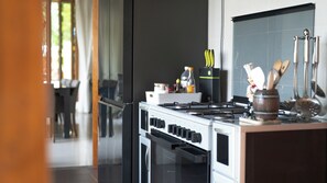 A kitchen with a stove, oven, and various kitchen utensils. - The Villa - Luxury Private Pool Villa (Langkawi)