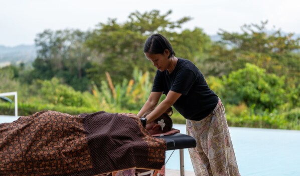 A person performing a massage on a patient lying on a treatment table outdoors. - The Villa - Luxury Private Pool Villa (Langkawi)