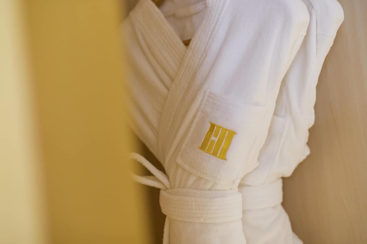 Túnica branca com emblema dourado na manga.
