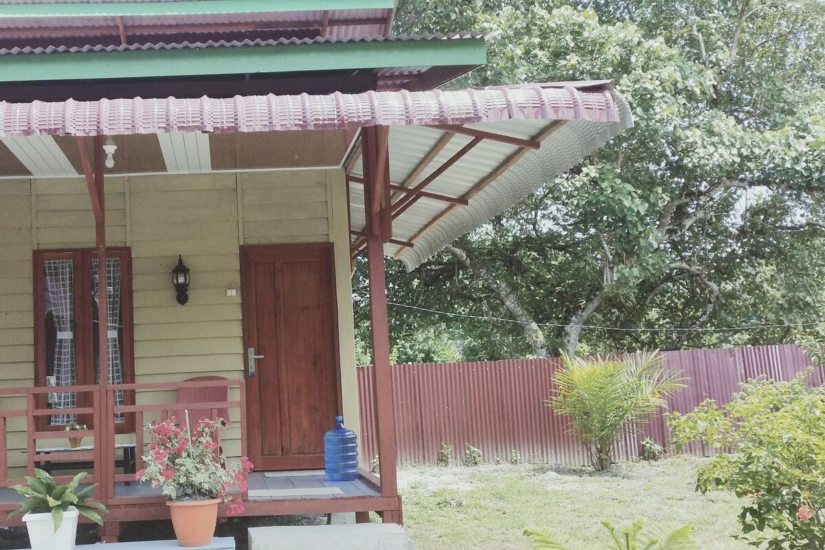 A traditional wooden building with a covered porch, a door, and a window.