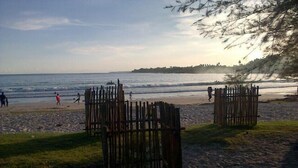 A beach with wooden structures, a sandy shore, and a calm sea.