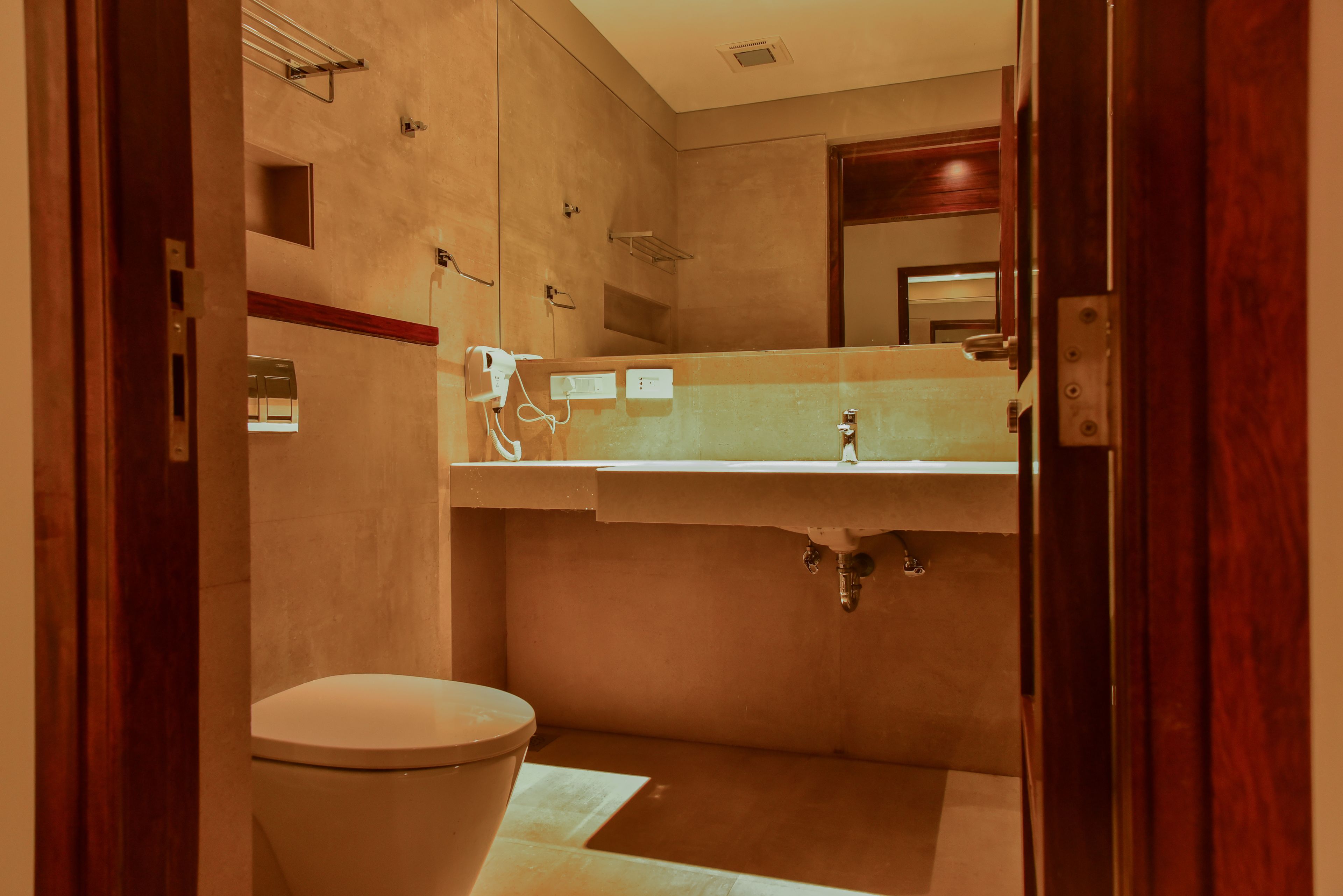 A bathroom with a toilet, sink, and mirror.