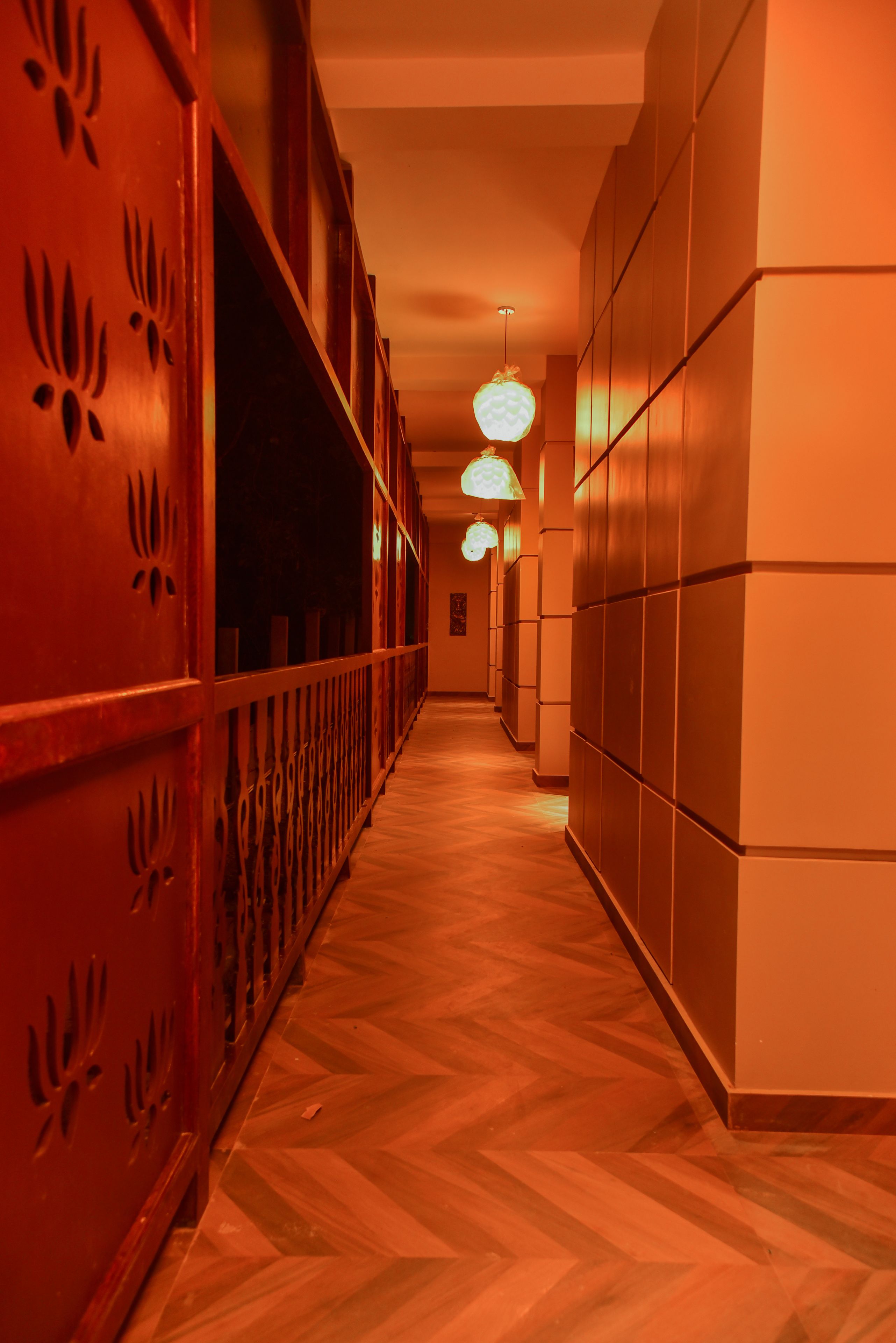 A corridor with wooden paneling and a herringbone floor.
