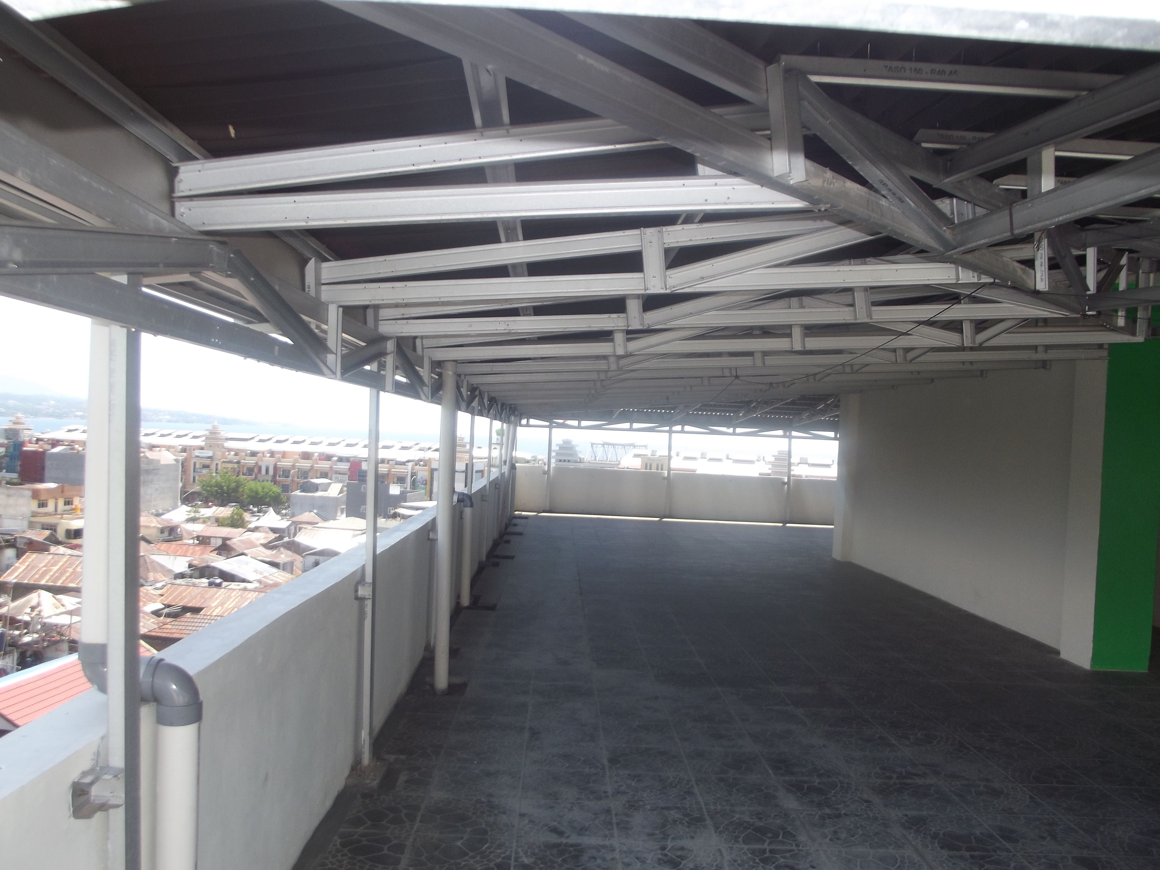 Un pasillo vacío con vistas a un paisaje urbano a través de amplios ventanales.