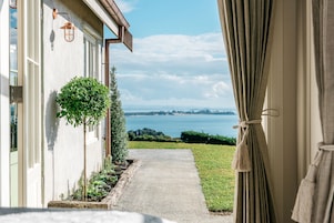 Um caminho conduz a uma vista panorâmica de um corpo d'água, com um edifício à esquerda e cortinas à direita.