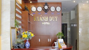 A reception desk with clocks, a wooden panel, and a sign that reads "KHÃNH DUY HOTEL". - Khanh Duy Hotel (Nha Trang)