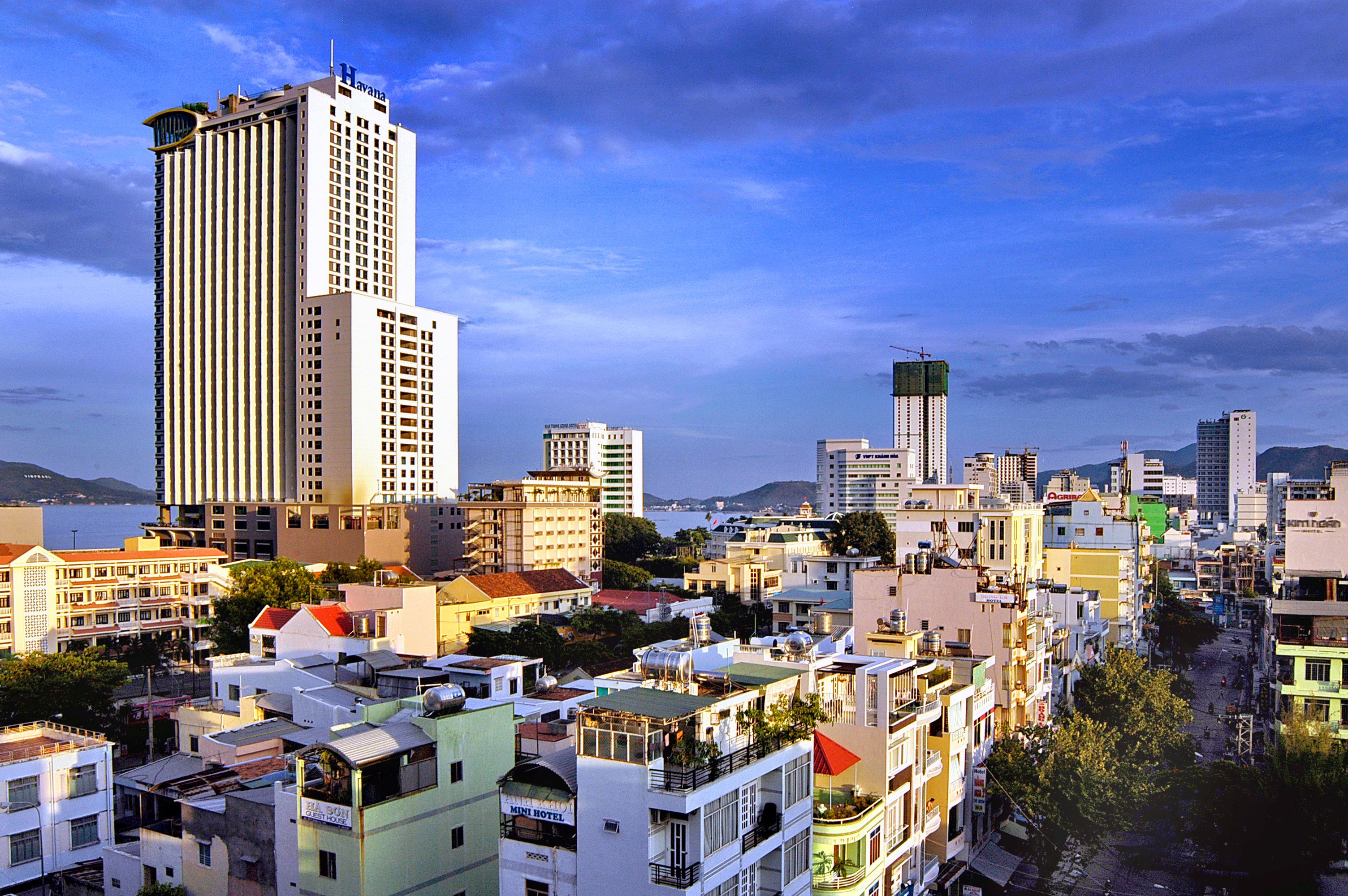 A cityscape with a prominent tall building, a variety of mid-rise buildings, and a mix of residential and commercial structures.