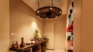 A narrow hallway with a wooden counter, a decorative plant, and a unique circular ceiling light fixture.