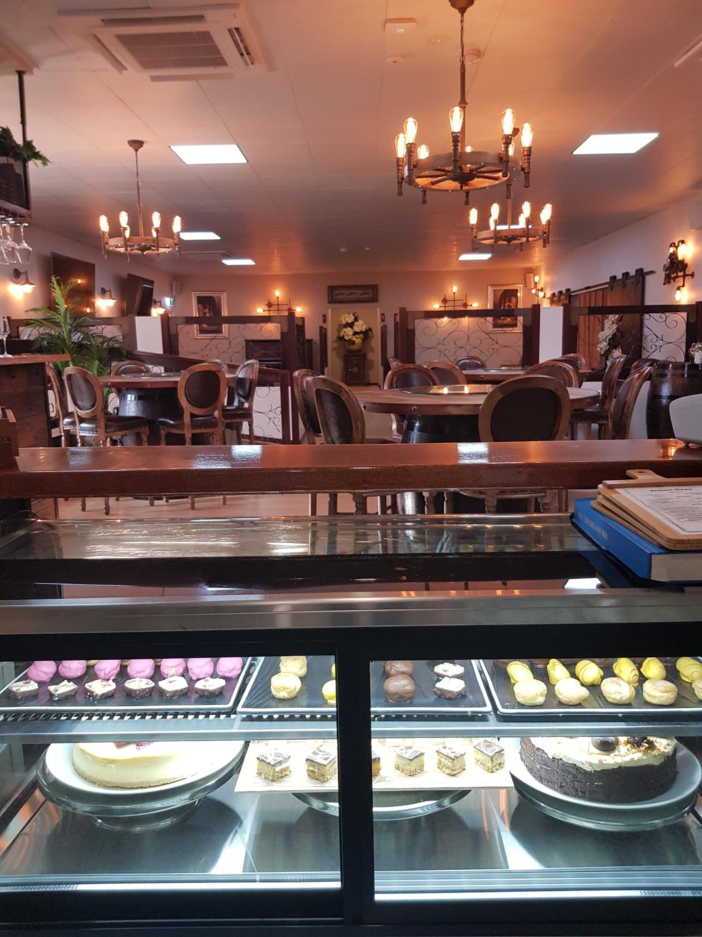 Una panadería con una vitrina de pasteles y pasteles.