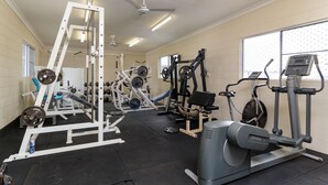 A gym with various exercise equipment, including a weight bench, a treadmill, and a stationary bike.