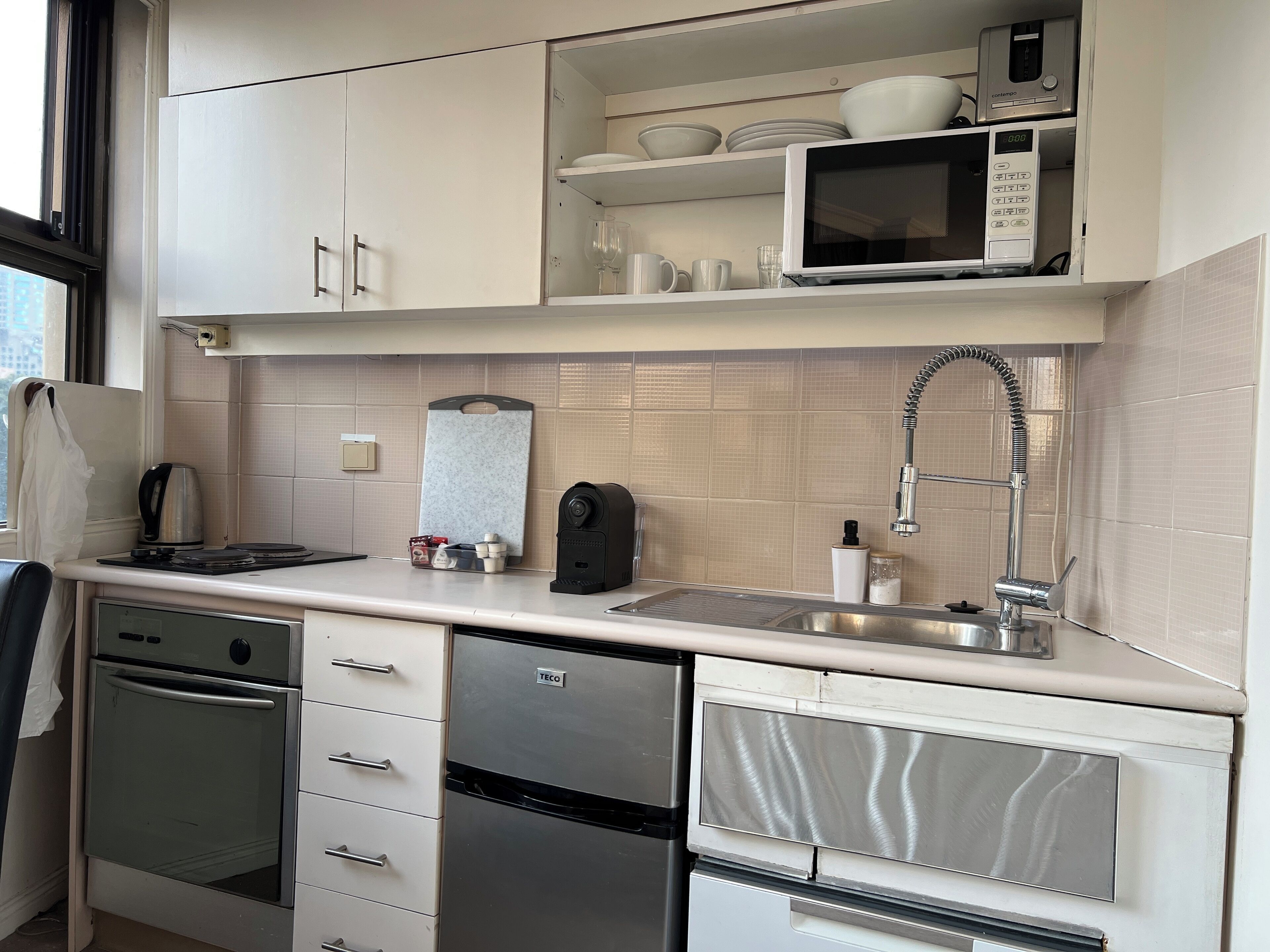 Una cocina moderna con microondas, pileta y electrodomésticos de acero inoxidable.