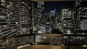 A balcony with a view of a cityscape at night, featuring high-rise buildings and a crescent moon. - Sydney Hyde Park Paxsafe Apartments (Darlinghurst)