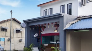 Un hotel con fachada moderna, un recibimiento acogedor y una banca en el exterior.