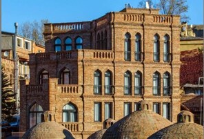 Un edificio histórico con ventanas arqueadas y un balcón.