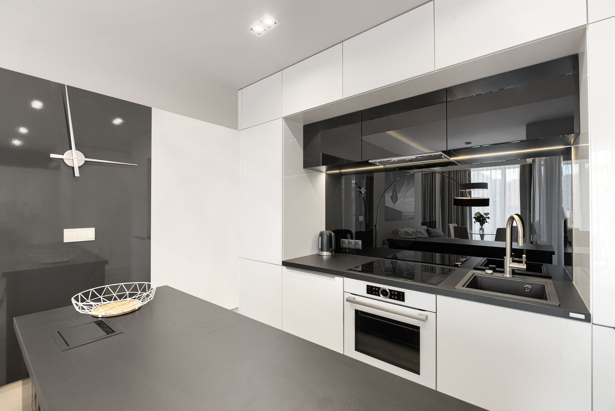 Une cuisine moderne avec un plan de travail noir, des appareils en acier inoxydable et un pare-feu noir.