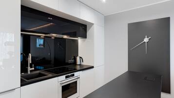 Eine moderne Küche mit schwarzem Arbeitsplatz, Edelstahlgeräten und einem minimalistischen Design.