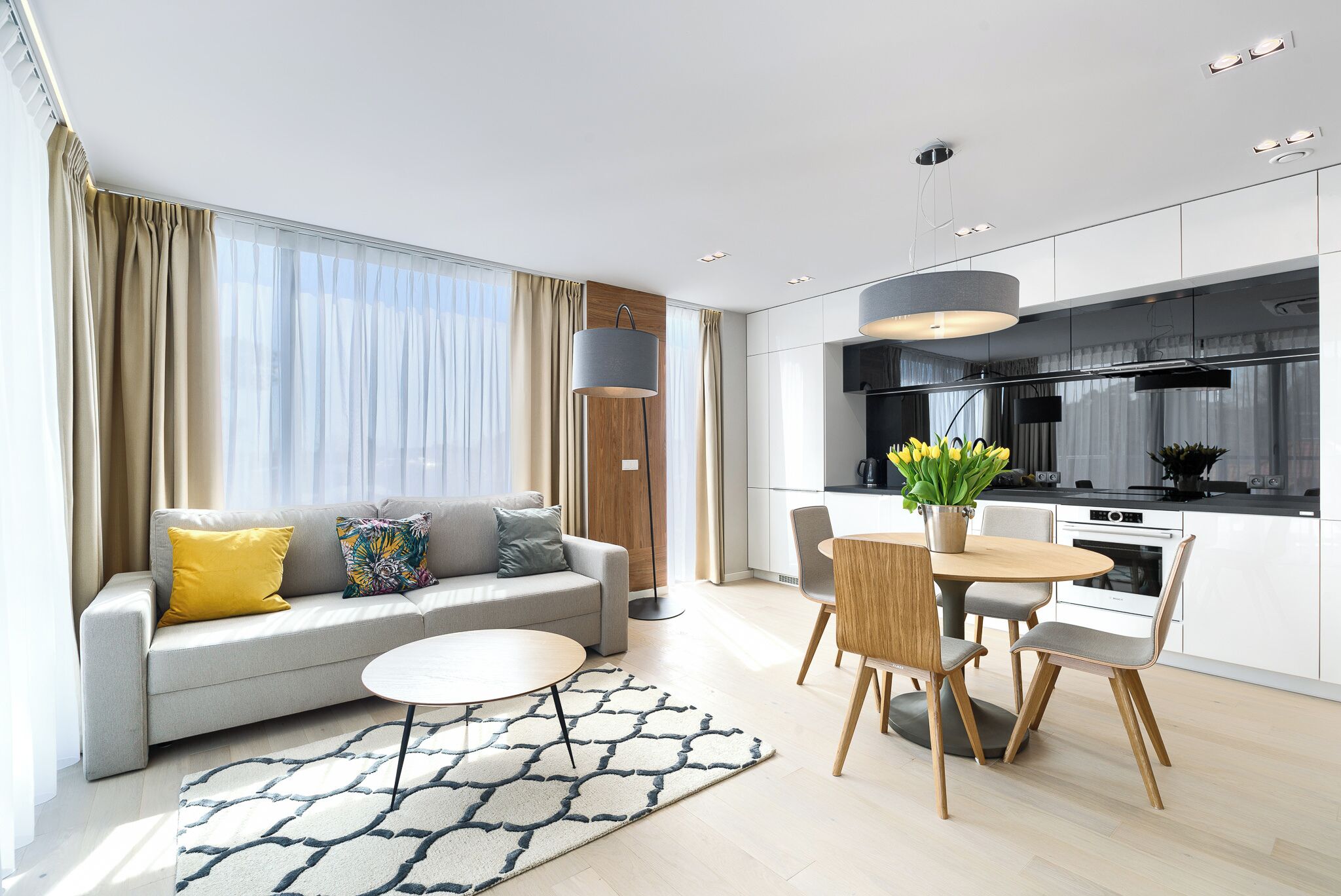 Una sala de estar moderna con sofá, mesa de centro y comedor con sillas y una mesa.