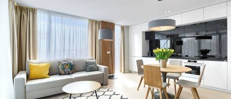 Una sala de estar moderna con sofá, mesa de centro y comedor con sillas y una mesa.