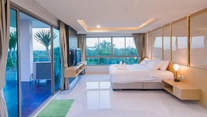 Quarto moderno com uma cama grande, uma escrivaninha e vista para o verde lá fora.