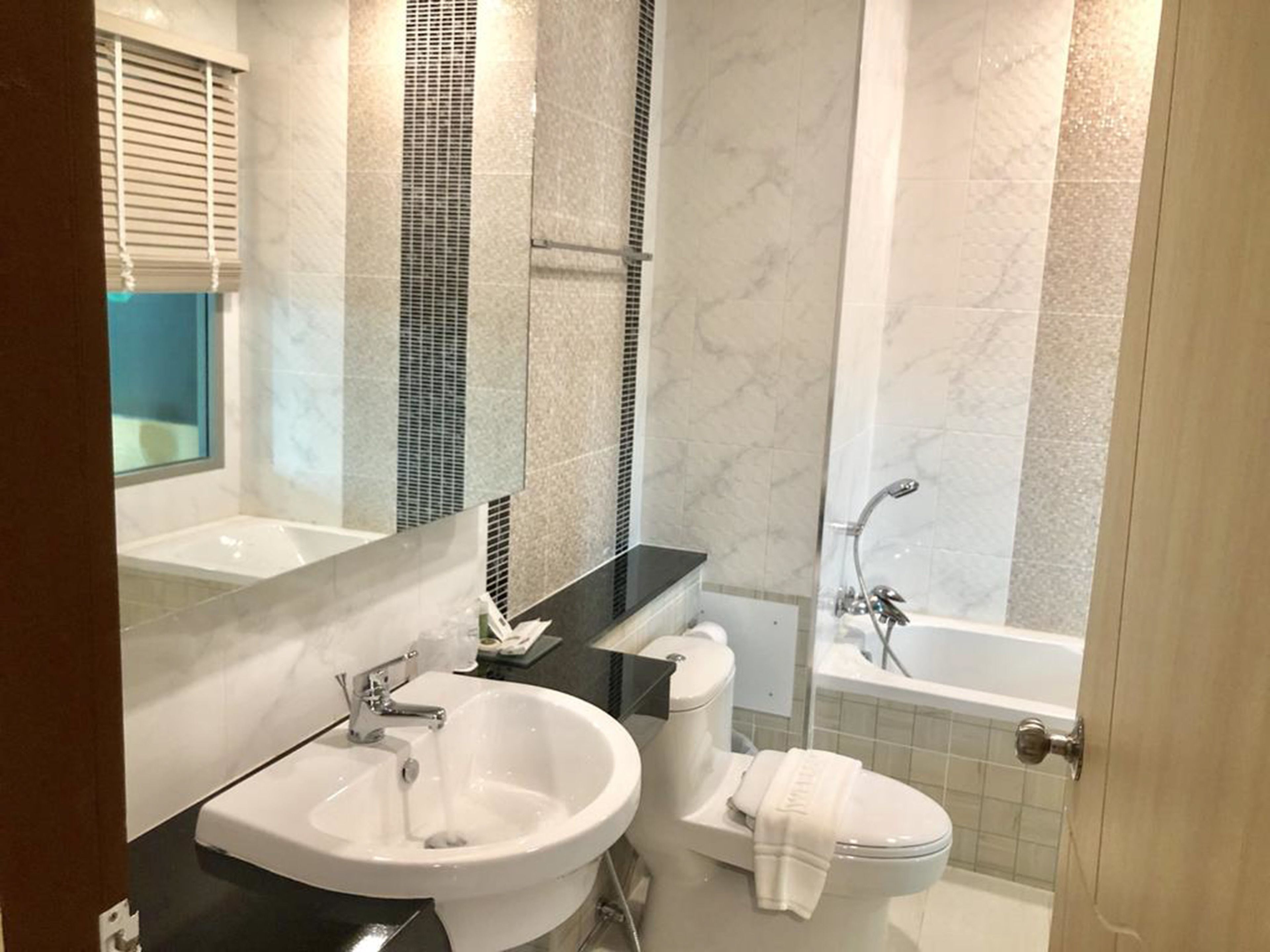 A modern bathroom with a large sink, toilet, and bathtub.