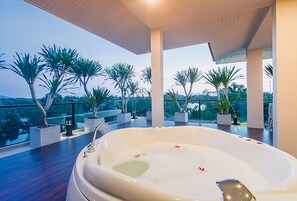 A hot tub on a balcony with a view of palm trees and a distant landscape. - The Peak Chanthaburi Hotel (Chanthaburi)