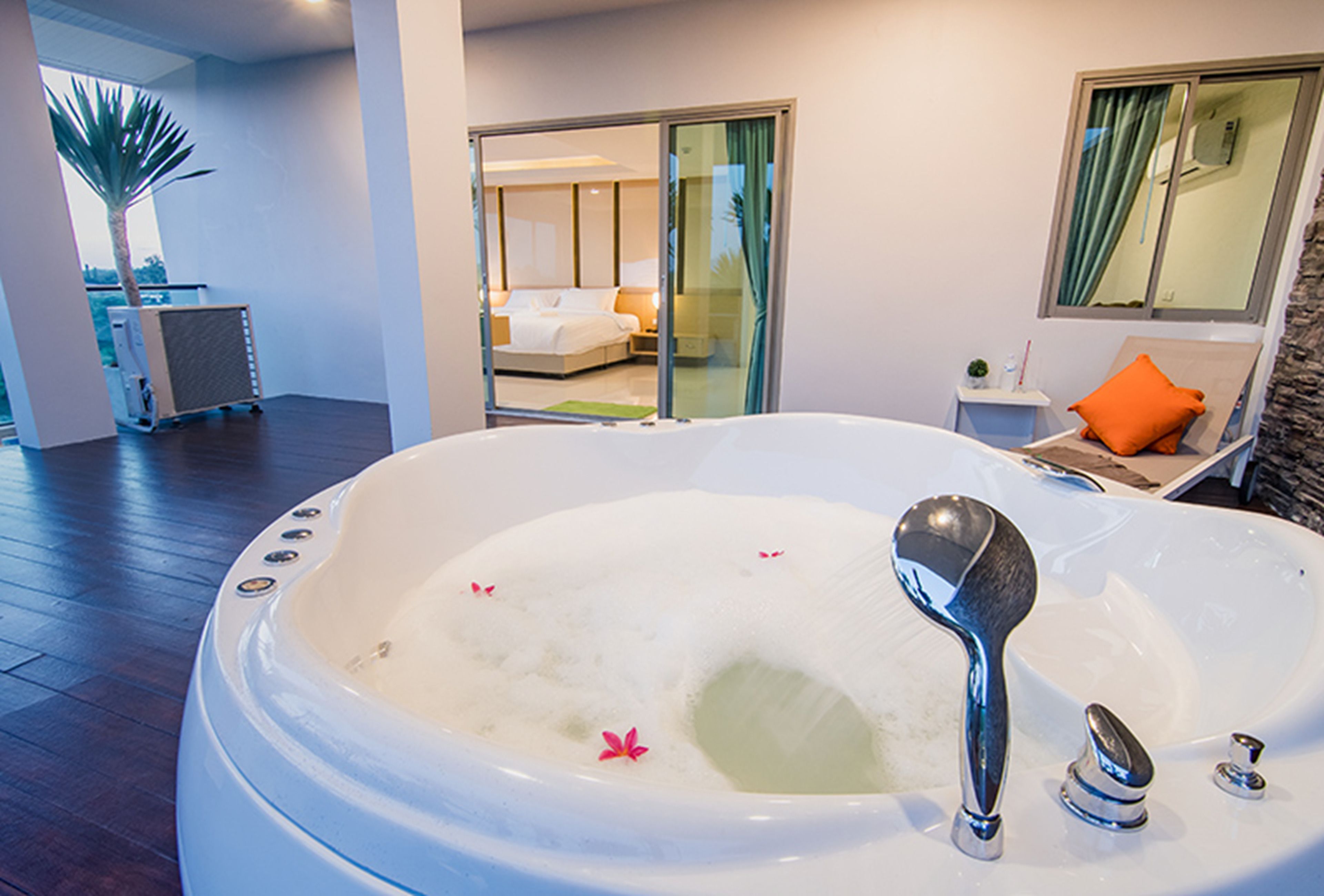 Un baño moderno con una bañera grande, ducha y un dormitorio con paredes de vidrio.