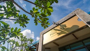 Um edifício com uma placa que diz "The Peacock Pool Villa 03".