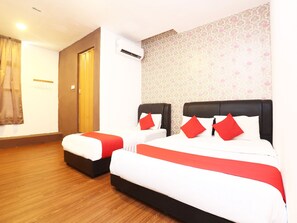 A hotel room with two beds, a wooden floor, an air conditioning unit, and a patterned wallpaper. - OYO 717 MR J Hotel Wakaf Che Yeh 2 (Kota Bharu)