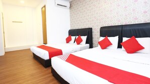 A hotel room with two beds, each with a black headboard and red pillows. There is a white air conditioning unit on the wall, and a patterned wallpaper on the adjacent wall. - OYO 717 MR J Hotel Wakaf Che Yeh 2 (Kota Bharu)