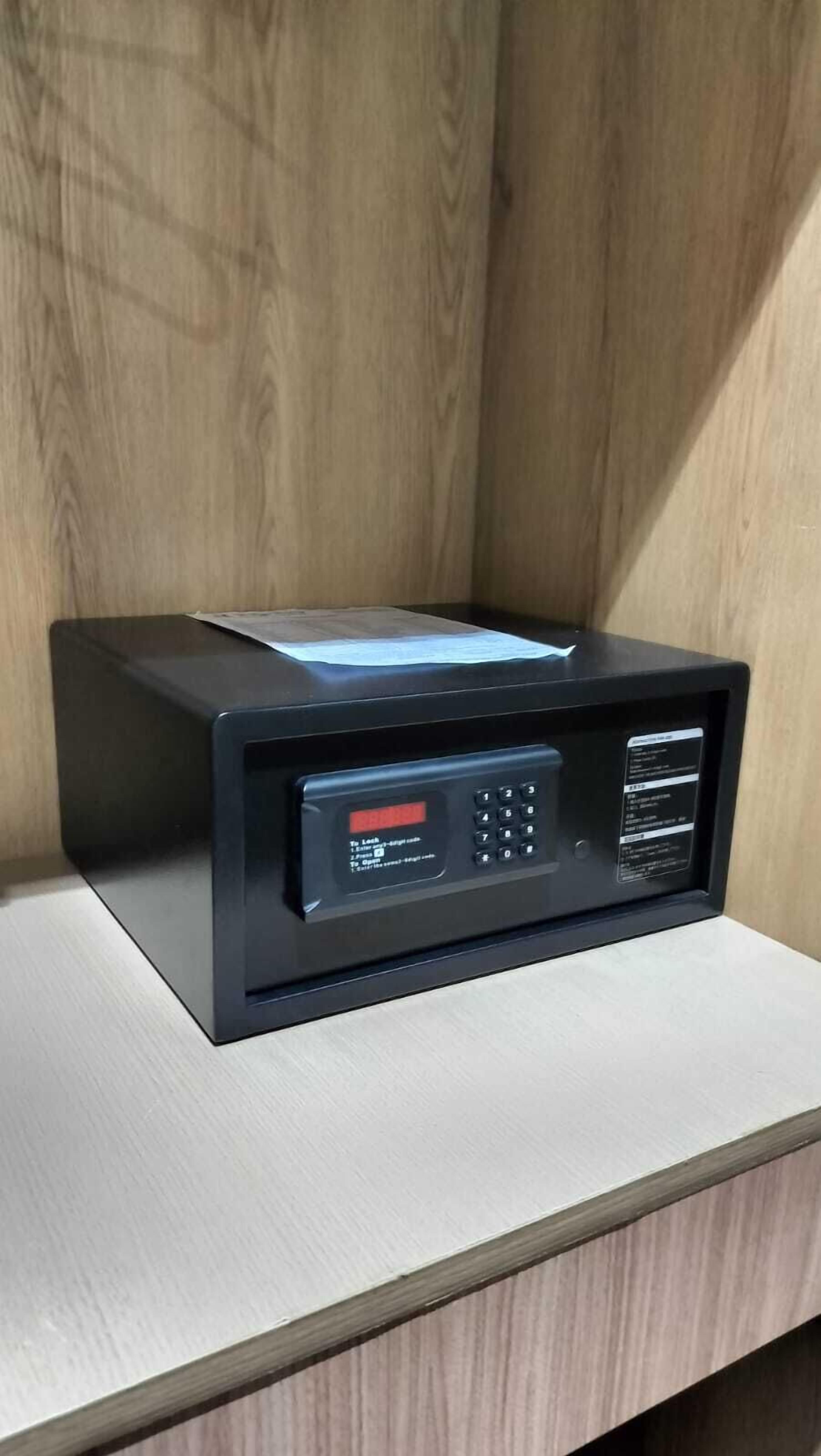 Un four à micro-ondes noir, doté d’un écran numérique et d’un clavier, posé sur un plan de travail de couleur claire.