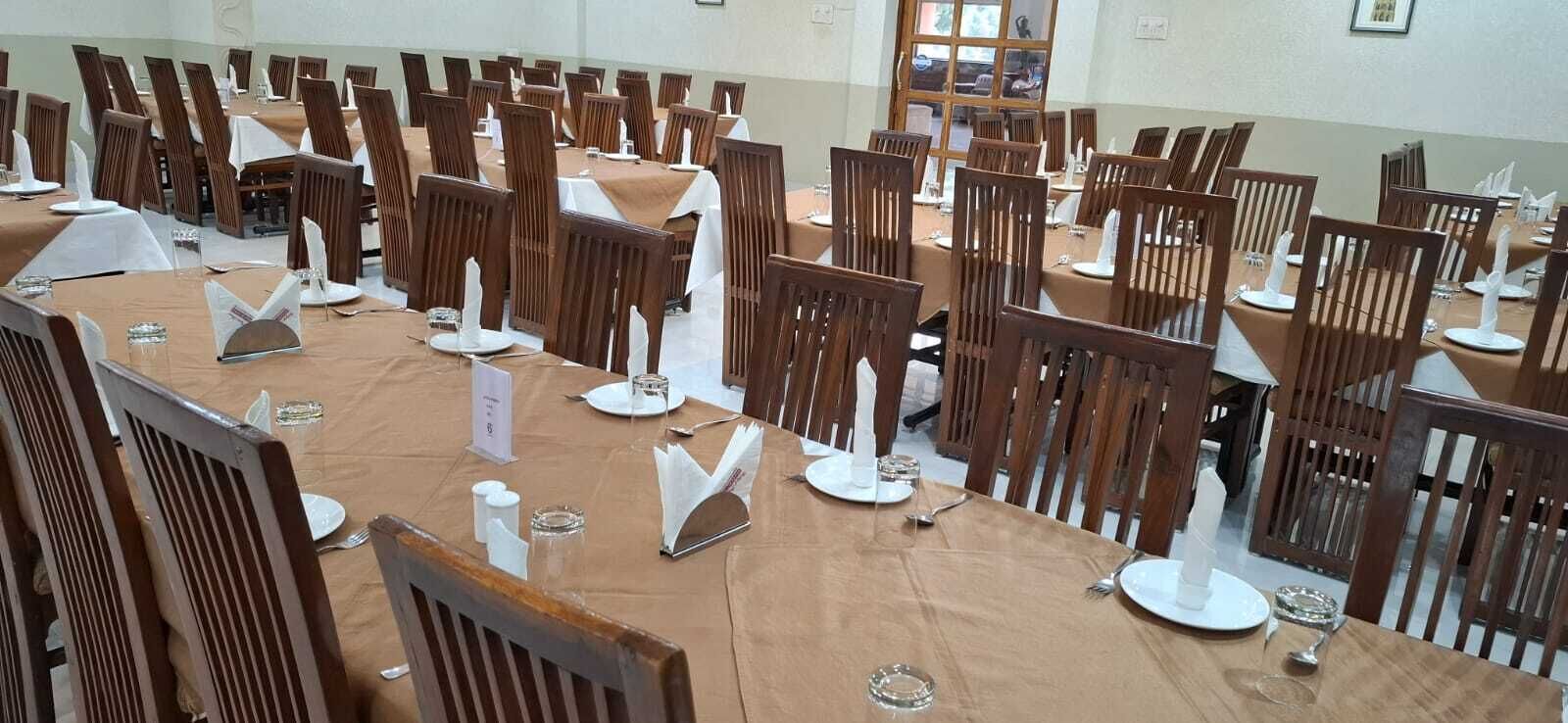 Un salón de conferencias con varias mesas y sillas dispuestas en filas.