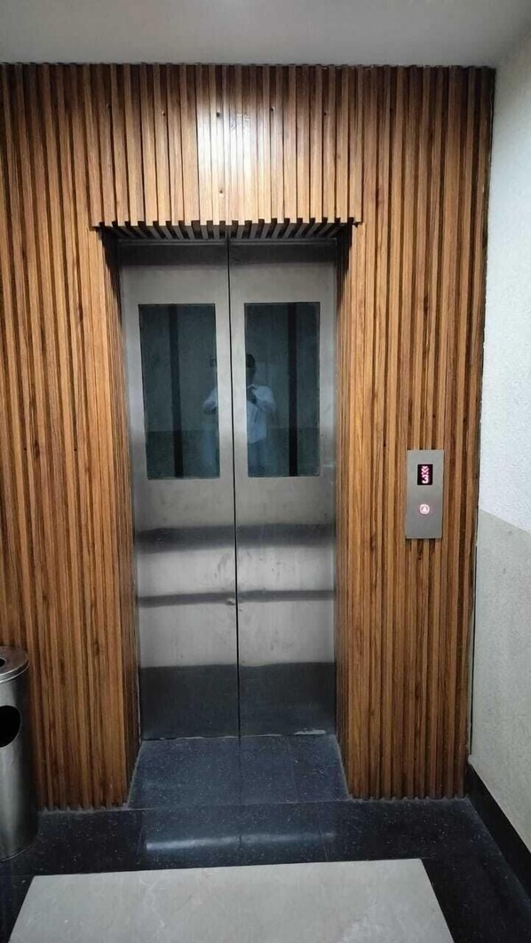 Un ascensor con paneles de madera y una pantalla digital.