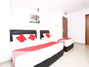 A hotel room with two beds, each with black headboards and red pillows. There is a small window with a picture of a tree, and a door to the right. - OYO 718 MR J Hotel Wakaf Che Yeh 1 (Kota Bharu)