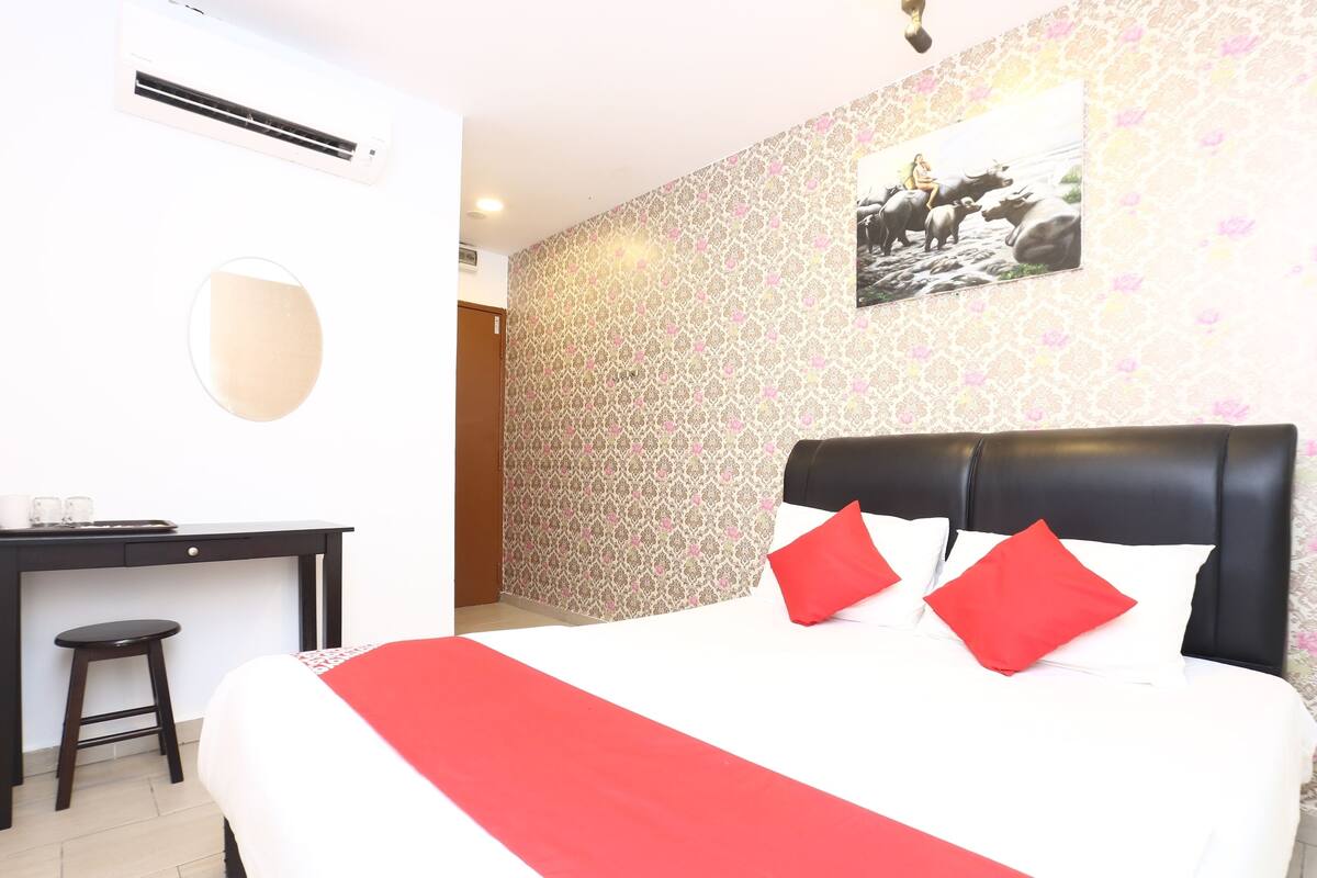 Une chambre d’hôtel avec un lit, un bureau et une chaise.