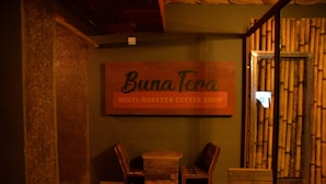 Et interiør i en café med flere propeller, et skilt der viser 'Buna Tera' og en væg af bambus.