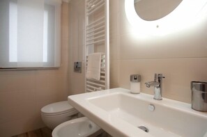 A modern bathroom with a white sink, a toilet, and a bidet. - B&B Raffaello a Mare (Montesilvano)
