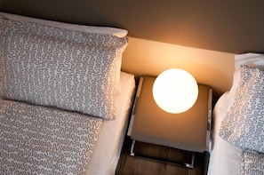 A bed with patterned pillows and a round bedside lamp. - B&B Raffaello a Mare (Montesilvano)