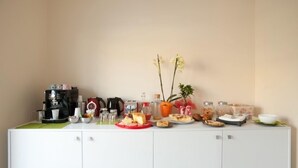 Uma cozinha compacta com cafeteira, torradeira e diversos alimentos sobre o balcão.