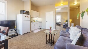 A compact living space with a kitchenette, a dining area, and a seating area with a sofa and a small table. - Cosy Berkeley Apartments Just Across UC Berkeley #206 (Berkeley)