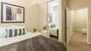 A bedroom with a bed, bedside tables, a mirror, and a wardrobe. - Cosy Berkeley Apartments Just Across UC Berkeley #206 (Berkeley)