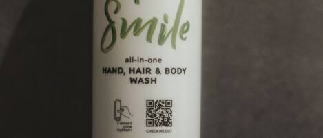 A bottle of hand, hair, and body wash with a smart care system QR code.